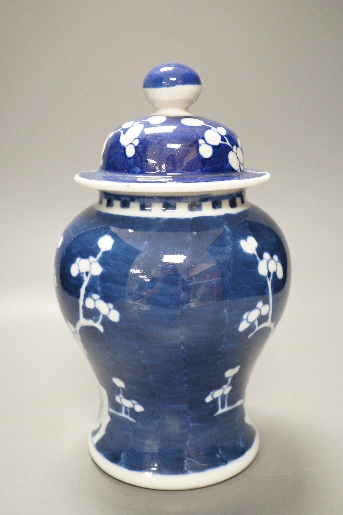 An early 20th century Chinese blue and white prunus vase and cover, 23cm